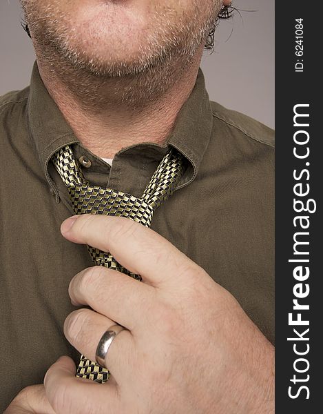 Man Fixing Tie Against Grey Background