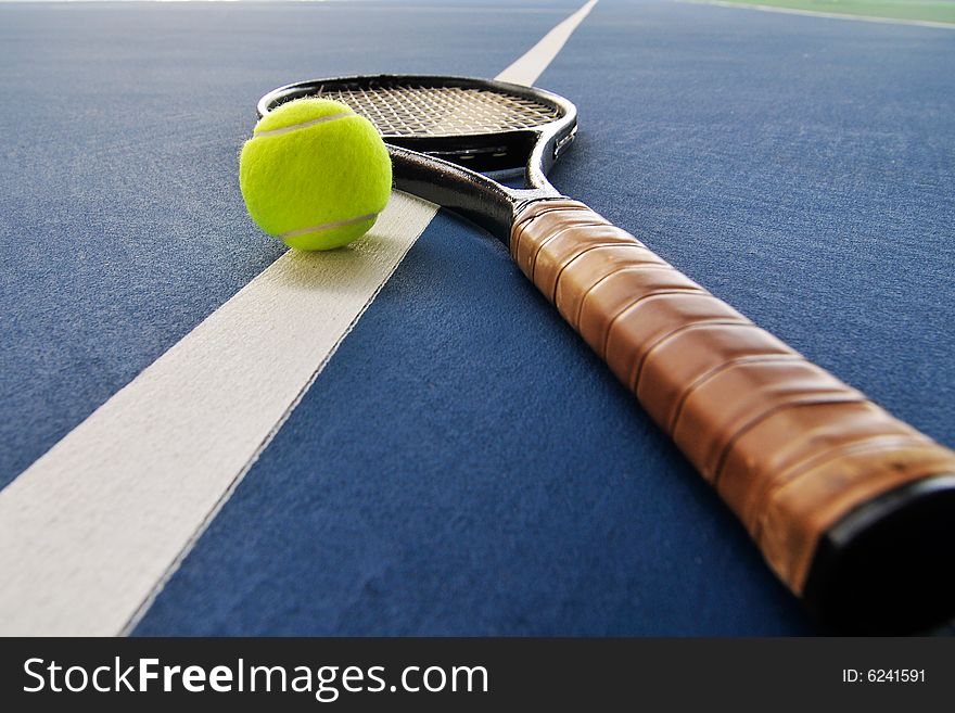 Tennis ball and racquet on a court line