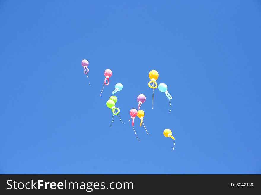 Colorful balloons flying in the blue sky.