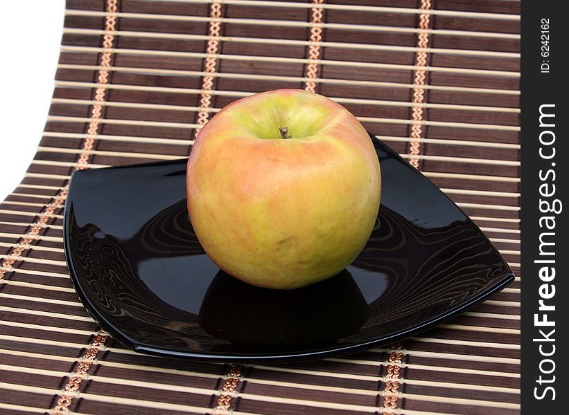 Apple on a black plate on a napkin