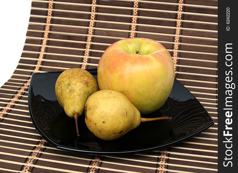 Apple and pears on a black plate on a 
napkin