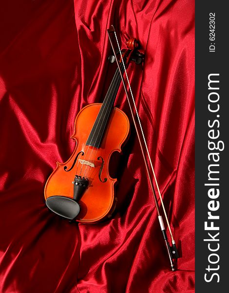 Violin and bow on red silk