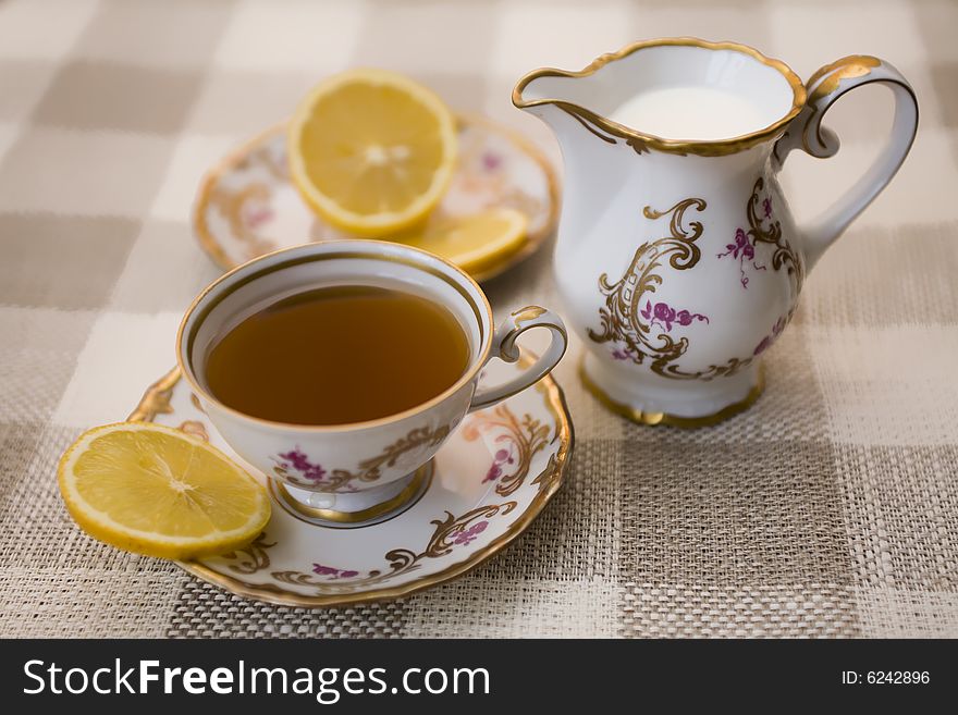A cup of tea with cuts lemon and milk. A cup of tea with cuts lemon and milk