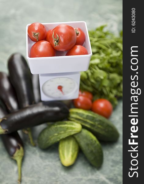 White kitchen scale and vegetable cucumber and tomato. White kitchen scale and vegetable cucumber and tomato