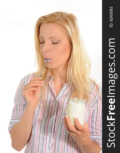 Young woman eating and enjoying yoghurt. Isolated on white background. Young woman eating and enjoying yoghurt. Isolated on white background.