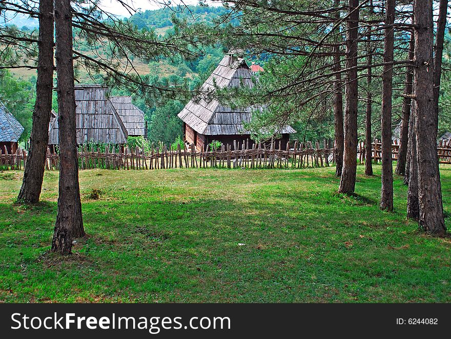 Ethnic Serbia, wooden house and fence over rural landscape