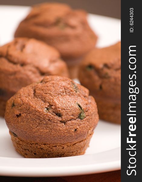 Freshly baked chocolate mint muffins on a white serving dish