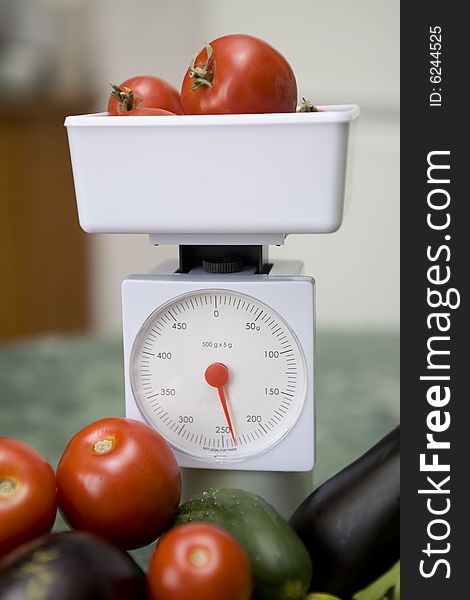 White kitchen scale and vegetable cucumber and tomato. White kitchen scale and vegetable cucumber and tomato