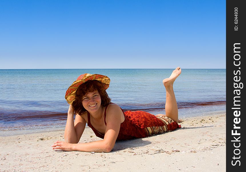 Girl in hat lie on sand sea beach. Girl in hat lie on sand sea beach