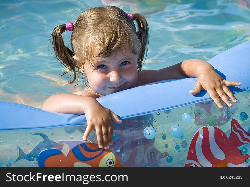 Nice little girl is smiling in the pool. Nice little girl is smiling in the pool.