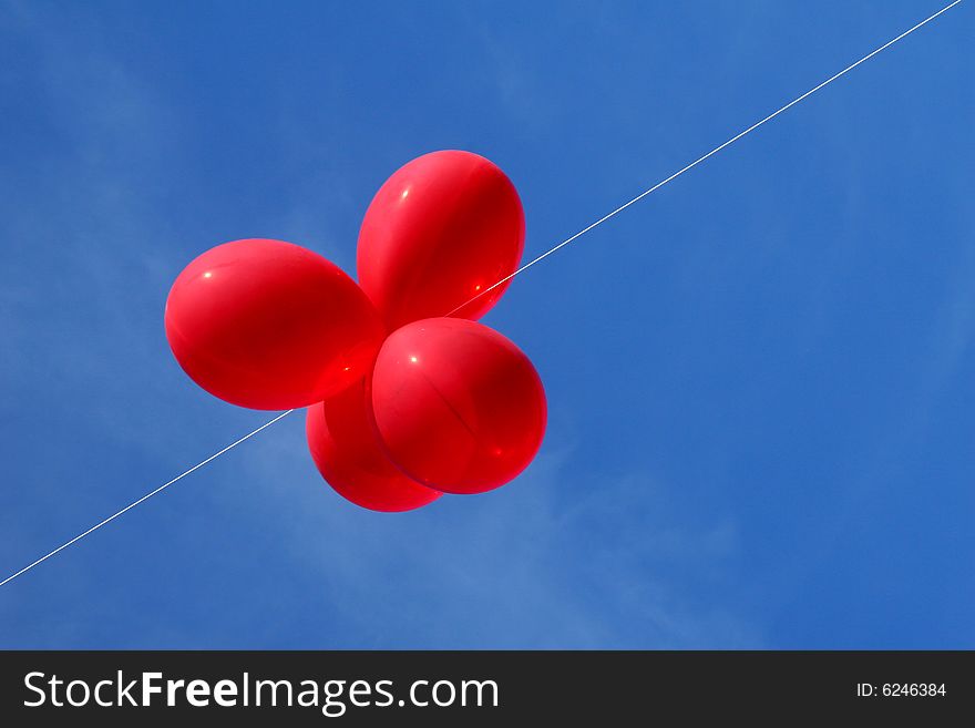 Bunch of red balloons against a blue sky