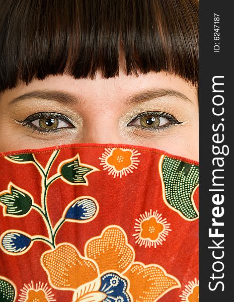 Portrait of young woman who is smiling and closing face with fan. Portrait of young woman who is smiling and closing face with fan