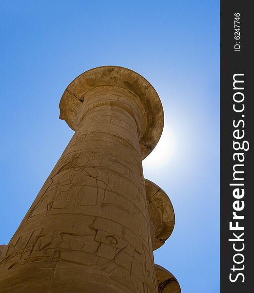 Egyptian column in luxor temple with blue sky and sun. Egyptian column in luxor temple with blue sky and sun