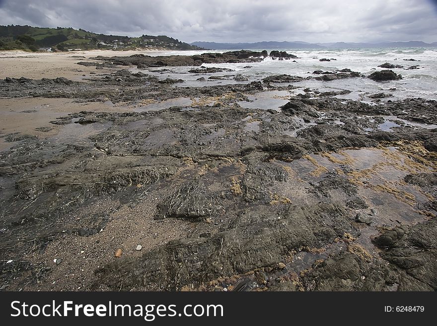 It shows a rocky Beach on the North Island of New Zealand