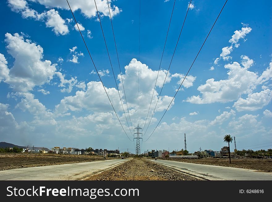 Tall towers carrying electricity cables on a huge rural landscape with the roads and the cables meeting at the horizon. Tall towers carrying electricity cables on a huge rural landscape with the roads and the cables meeting at the horizon