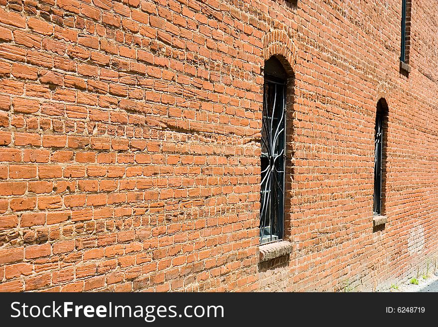 An old brick building with iron and mesh windows. An old brick building with iron and mesh windows