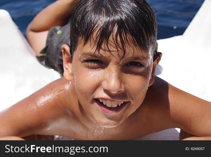 Smiling boy coming out of the water during summer sports. Smiling boy coming out of the water during summer sports
