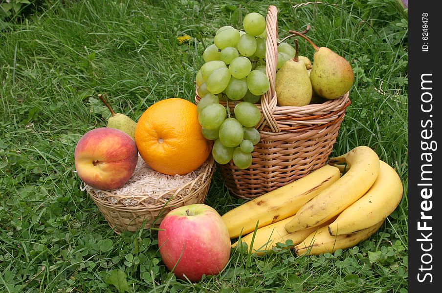 Fruit in a basket in a grass on 
a lawn. Fruit in a basket in a grass on 
a lawn