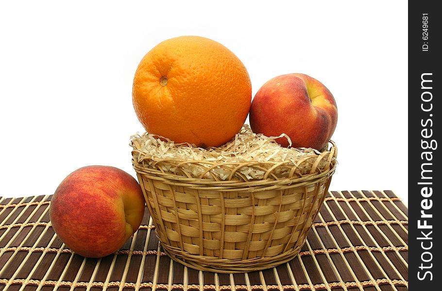 Peaches and orange in a yellow basket