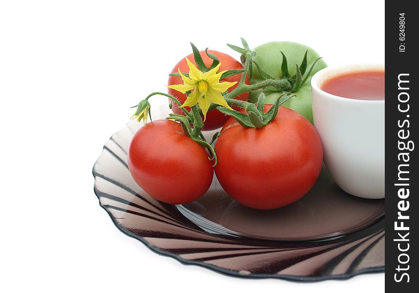 Tomatoes red and their yellow flower and tomato juice