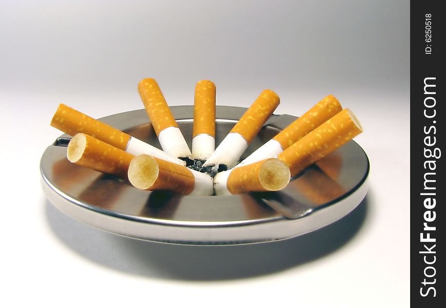 Some the extinguished cigarettes in an ashtray. Some the extinguished cigarettes in an ashtray