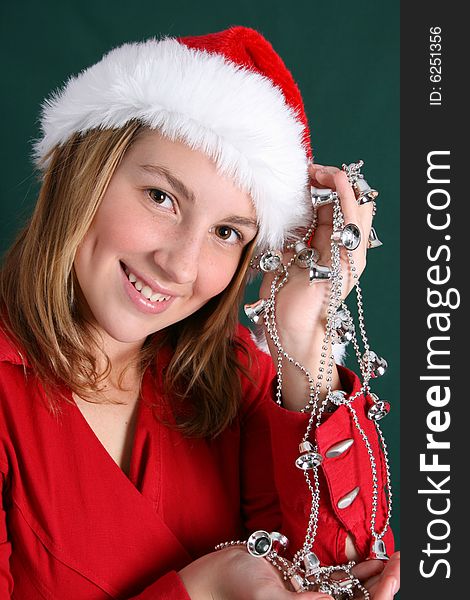 Teenager in red holding a silver string with bells. Teenager in red holding a silver string with bells