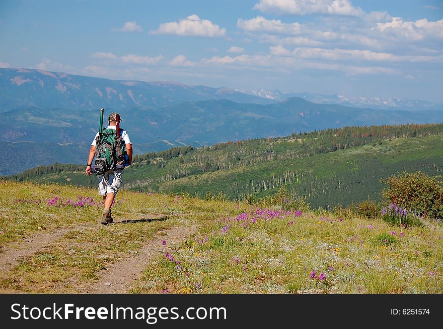 A hiker with a backpack hiking in the Colorado mountains.