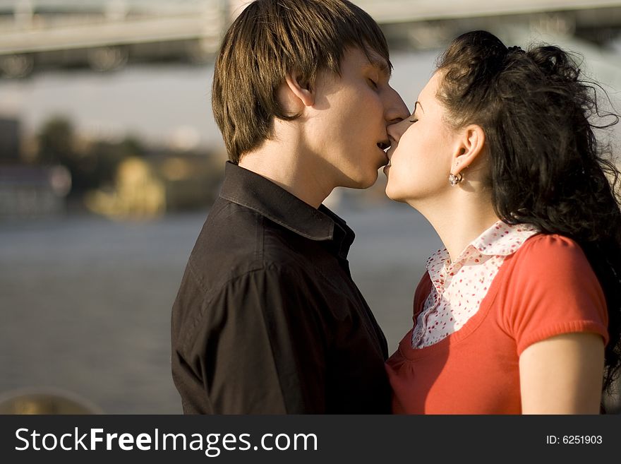 Outdoor portrait of young loving couple kissing each other