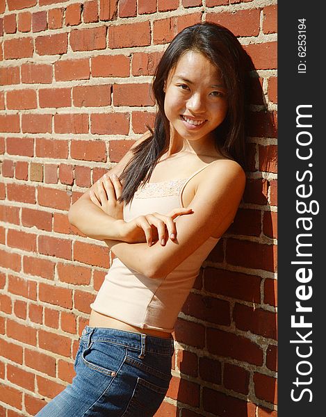 Fashionable young woman against red brick wall. Fashionable young woman against red brick wall.