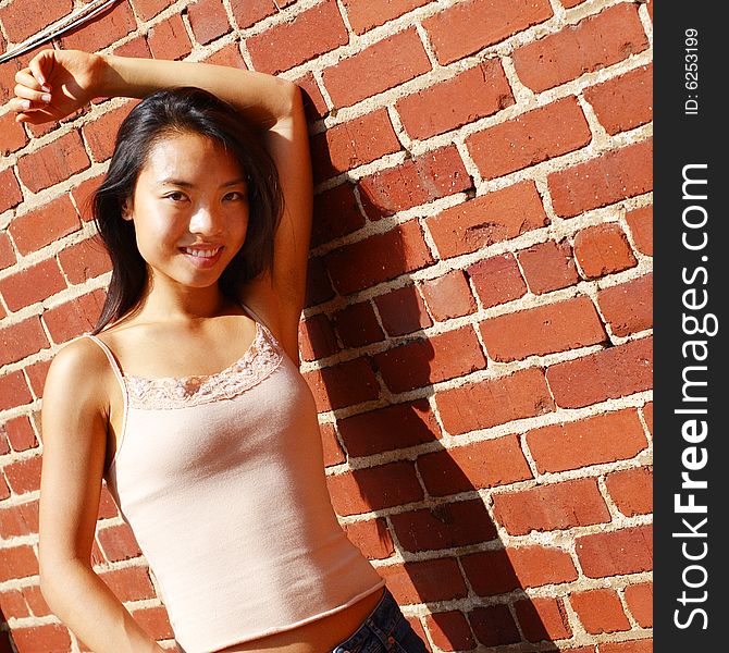 Fashionable young woman against red brick wall. Fashionable young woman against red brick wall.