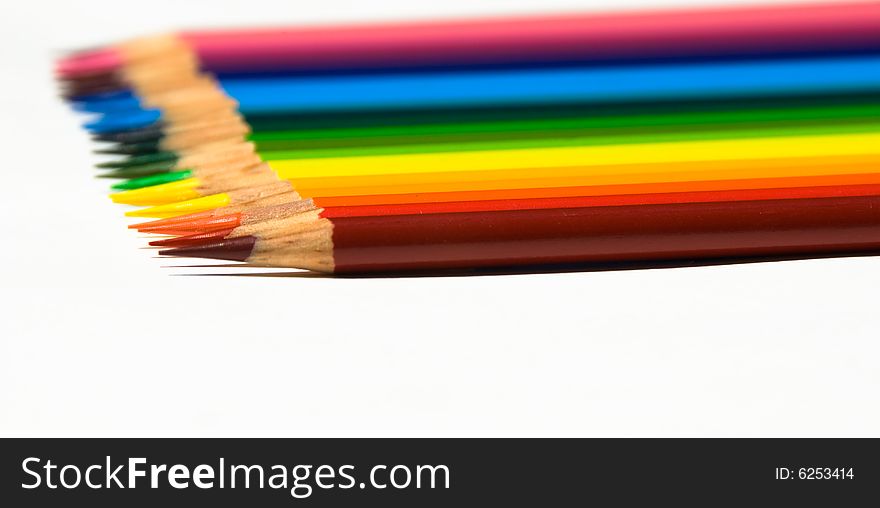 Rows of brightly colored pencils in a horizontal rainbow pattern facing right while isolated on a white background. Rows of brightly colored pencils in a horizontal rainbow pattern facing right while isolated on a white background