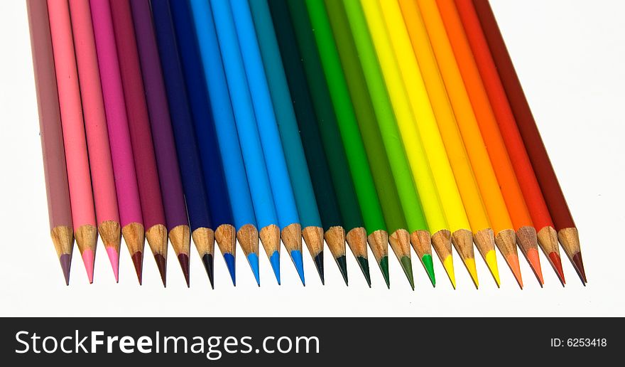 Rows of sharp and brightly colored pencils in a rainbow pattern facing downward while isolated on a white background. Rows of sharp and brightly colored pencils in a rainbow pattern facing downward while isolated on a white background