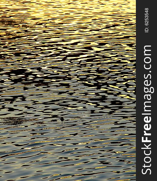 A suggestive shot of water of a river at the sunset useful for backgrounds. A suggestive shot of water of a river at the sunset useful for backgrounds