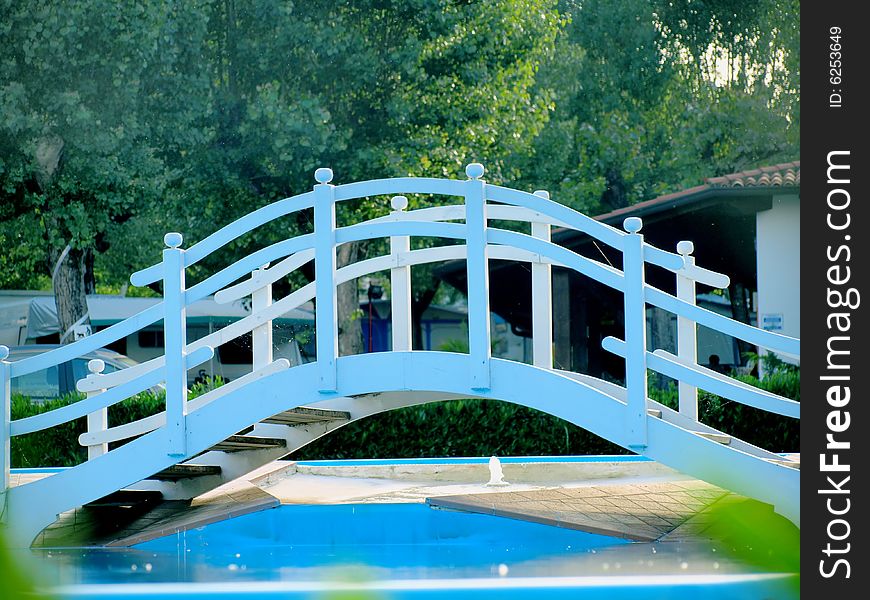 A funny blue bridge across a pool