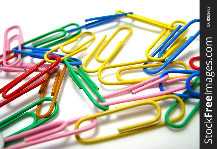 An assortment of multi-colored paper clips on a white background. An assortment of multi-colored paper clips on a white background