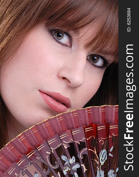 Close up portrait of cute young lady fanning herself with decorative spanish fan. Close up portrait of cute young lady fanning herself with decorative spanish fan