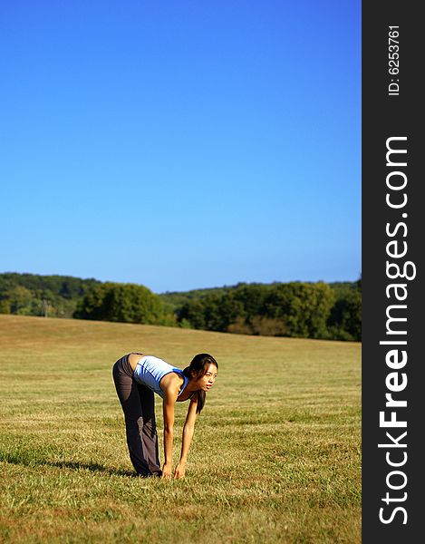 Girl Practicing Yoga In Field