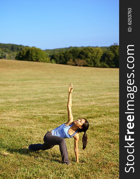 Girl practicing yoga in a summer meadow. Girl practicing yoga in a summer meadow.