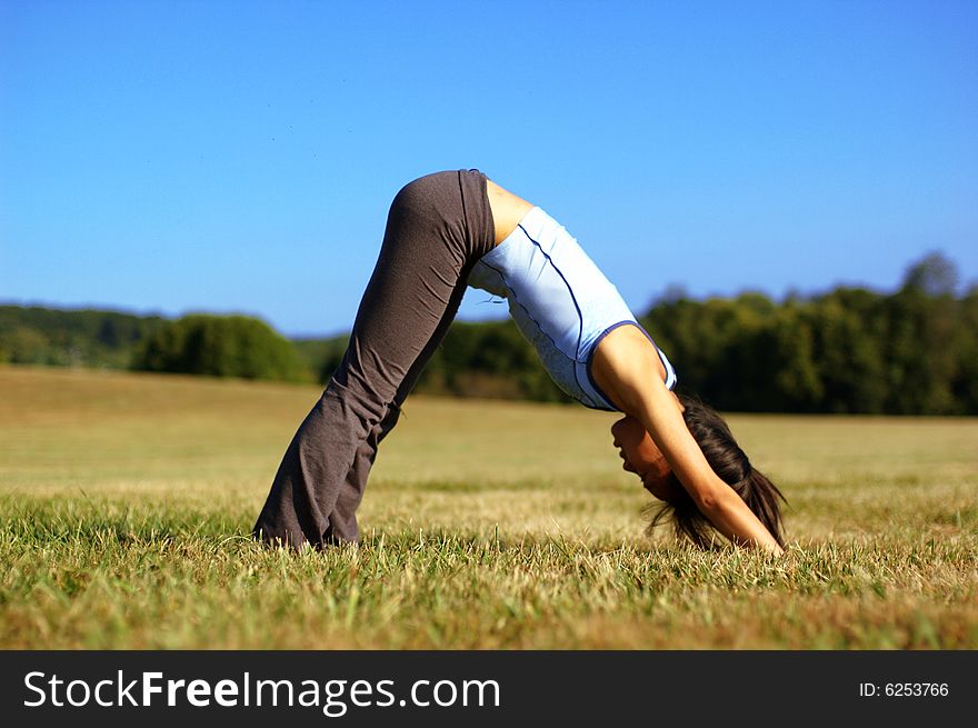 Girl Practicing Yoga In Field