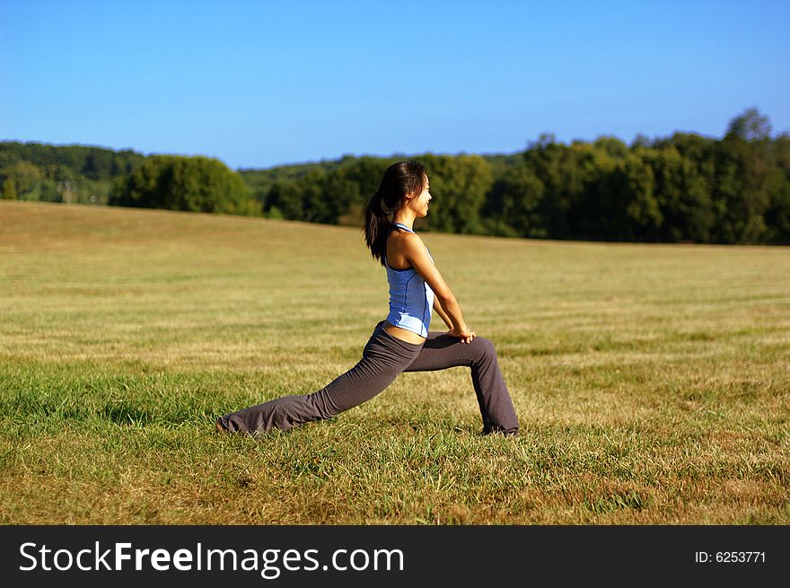 Girl Practicing Yoga In Field