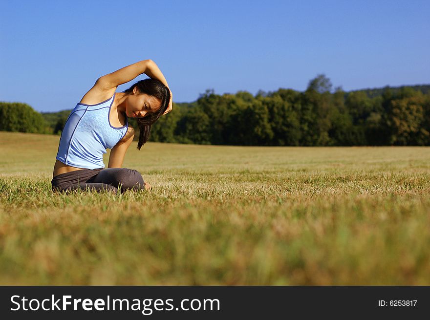 Girl Practicing Yoga In Field