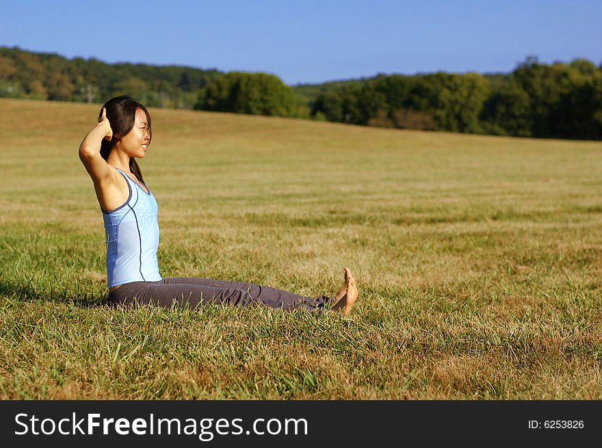 Girl practicing yoga in a summer meadow. Girl practicing yoga in a summer meadow.