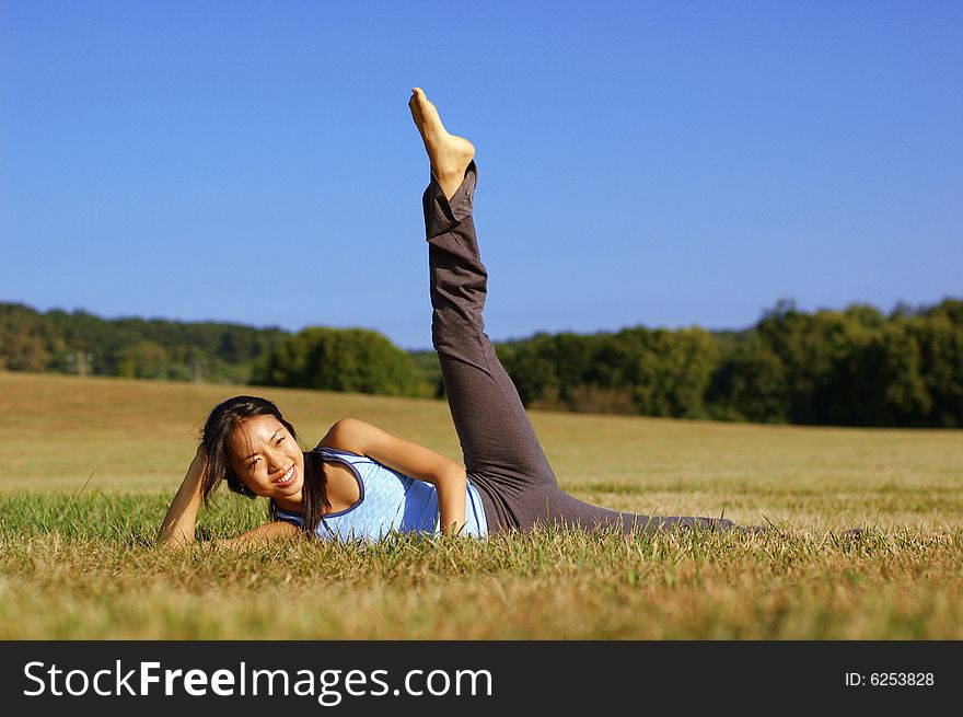 Girl Practicing Yoga In Field