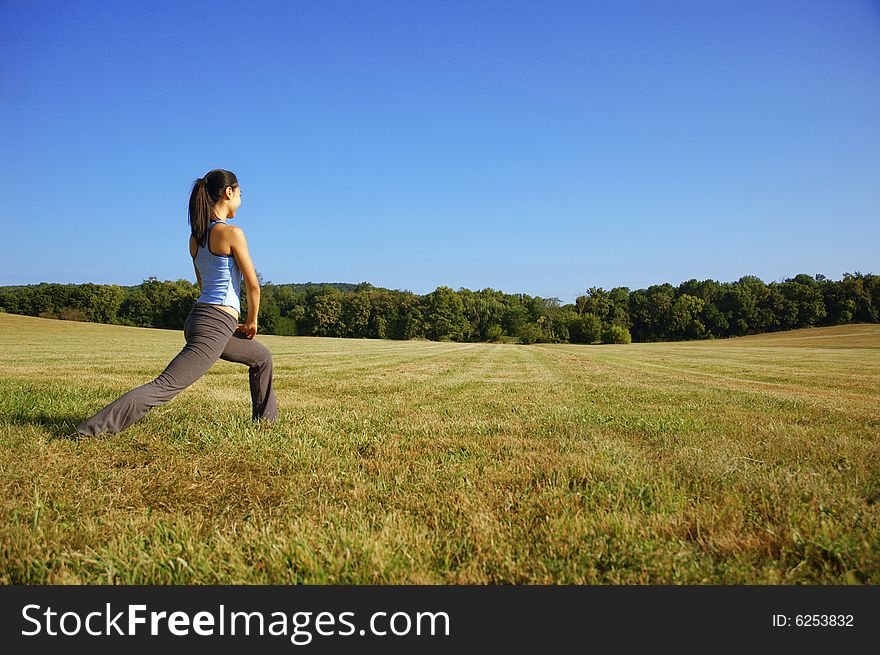 Girl practicing yoga in a summer meadow. Girl practicing yoga in a summer meadow.