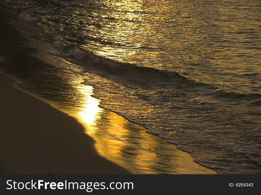 A beach and waves at sunset. A beach and waves at sunset