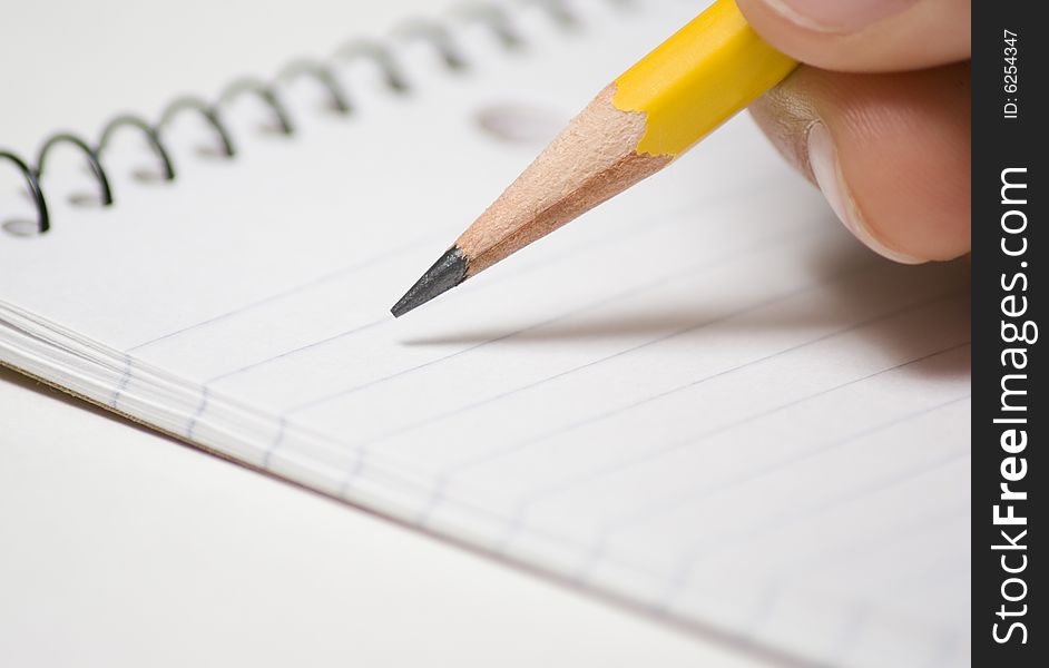 Note pad with pencil being held by a person. Note pad with pencil being held by a person