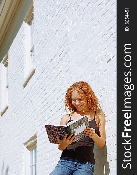 Attractive urban girl against white brick wall.