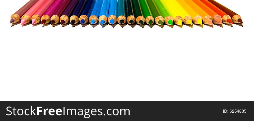 Rows of brightly colored pencils in a diminishing perspective rainbow pattern facing downward while isolated on a white background. Rows of brightly colored pencils in a diminishing perspective rainbow pattern facing downward while isolated on a white background