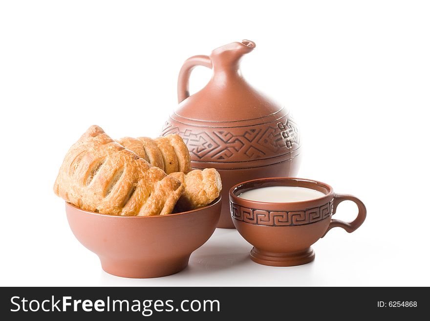 Appetizing pie, jug and cup of milk on a white background