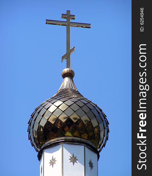 The gold dome of church shines in sun beams